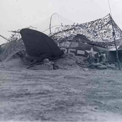 Privates First Class Perry and McBride using downed aircraft as foxhole