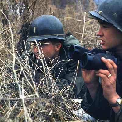 Two soldiers crouching in tall grass