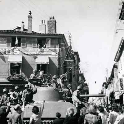 Civilians greet 45th soldiers on a tank