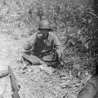 Soldier eating while sitting on the ground