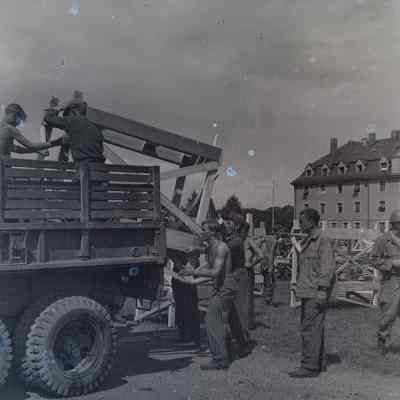 Soldiers and German prisoners constructing bunk beds