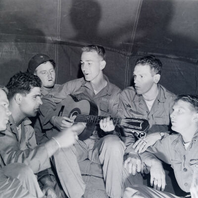 Soldiers singing accompanied by a guitar