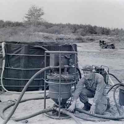 Soldier operating a water purification system