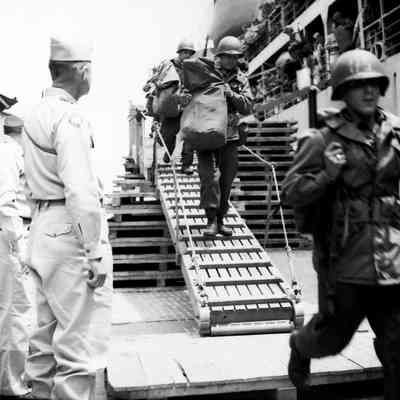 General Styron watching soldiers coming down gangway from ship