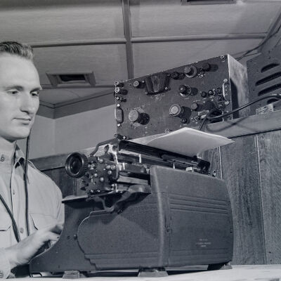 Soldier at desk with a typewriter and radio gear