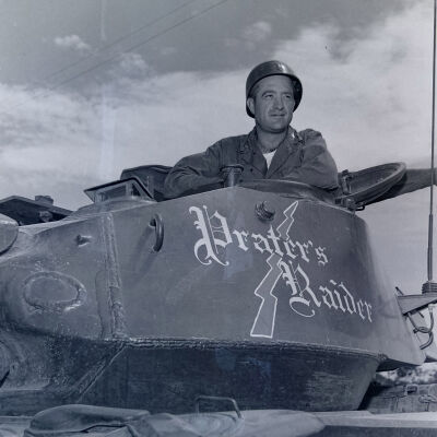 Soldier in a tank turret emblazoned with "Prater's Raider"