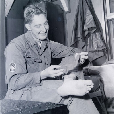 Soldier sitting on his bunk putting on socks