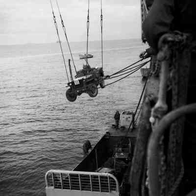 Soldiers loading Jeep into landing craft