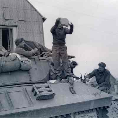 Soldiers clearing debris off of tank destroyer