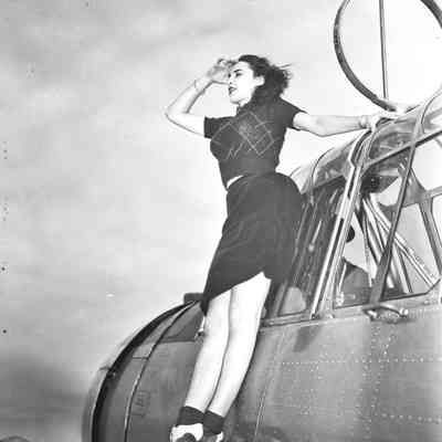 Woman posing on aircraft wing