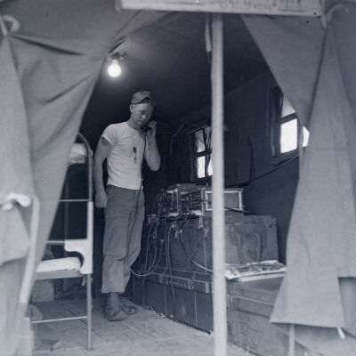 Soldier in tent operating a radio