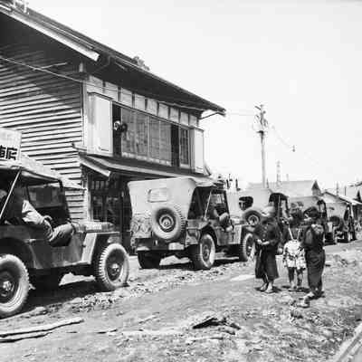 Japanese children watching jeep convoy