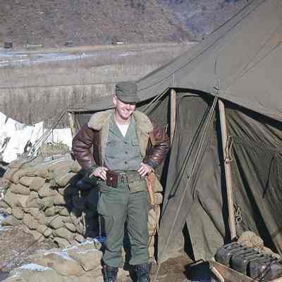 Soldier posing next to tent