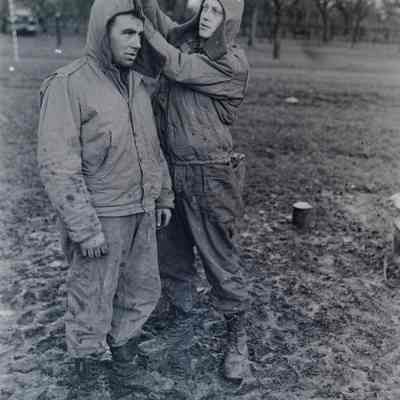 Soldier helping zip the hood of another soldier