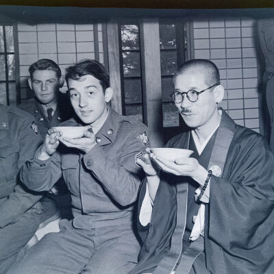 Soldiers eating with Japanese civilian