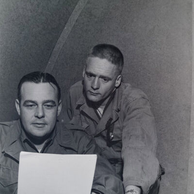 Two soldiers examining a document in an office