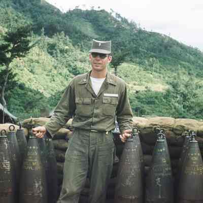 Chaplain posing with artillery shells