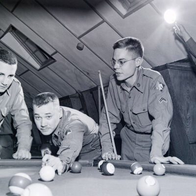 Soldiers shooting pool in a recreation hall