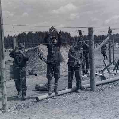 Prisoners of war fixing barbed wire fence