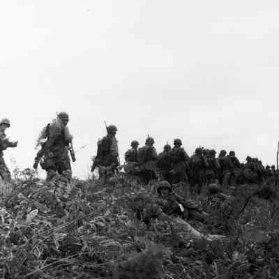 Soldiers marching through a field