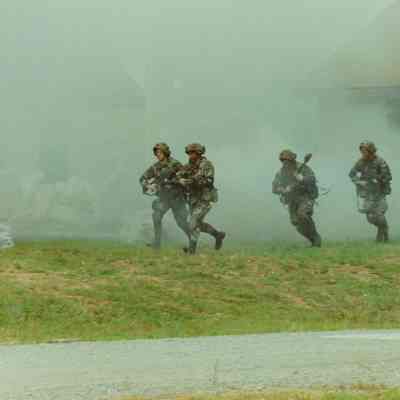 Soldiers advancing through smoke in training village