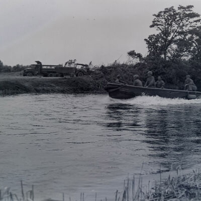 Soldiers in a motorboat on a river