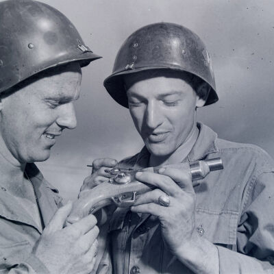 Two soldiers examining an antique pistol
