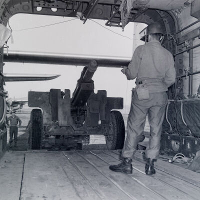 Loading an artillery piece into a C-119 aircraft
