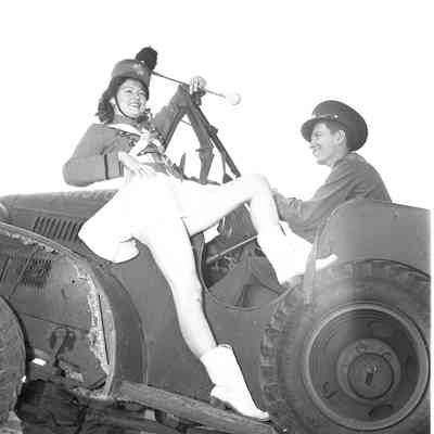 Majorette posing on the side of a command car