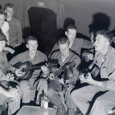 Soldiers singing accompanied by guitars and a fiddle