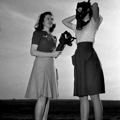 Girls trying on gas masks