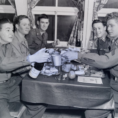A group of soldiers drinking champagne in a mess hall
