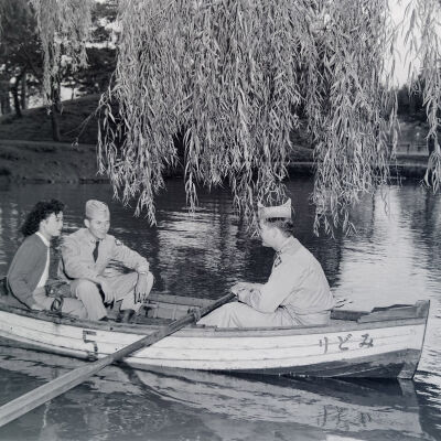 Two soldiers in a rowboat with a Japanese woman