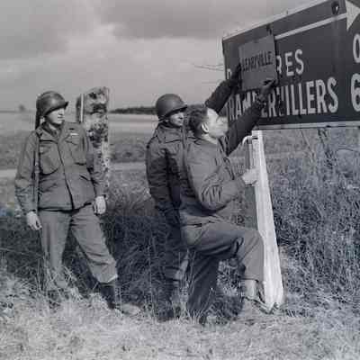 Soldiers hanging sign to rename liberated city
