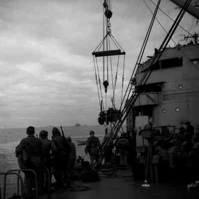 Soldiers loading Jeep into landing craft
