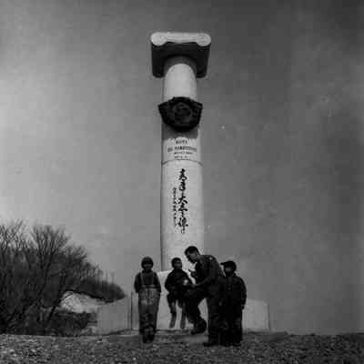 Soldier and kids in front of monument to W. S. Clark at Sapporo Agricultural College