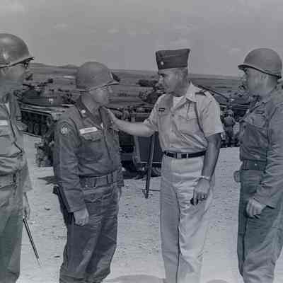 Group of officers talking behind the tank practice range