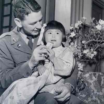 Portrait of a soldier with a small Japanese child on his lap