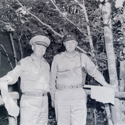 General Styron and another General in front of a fence