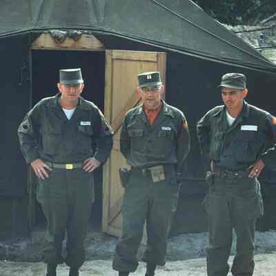 Three soldiers posing outside of tent