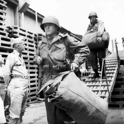 General Styron watching soldiers coming down gangway from ship