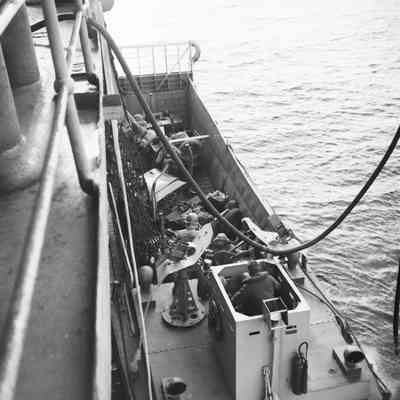 Landing craft loaded with two Jeeps at ships' side