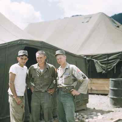 Three soldiers pose in front of a tent
