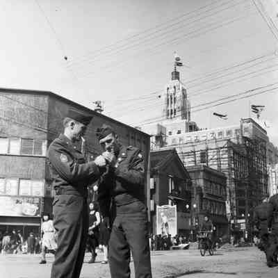 Soldiers lighting a cigarette in the street