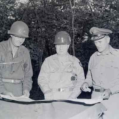 Generals Styron and Allen study a map with another unknown general