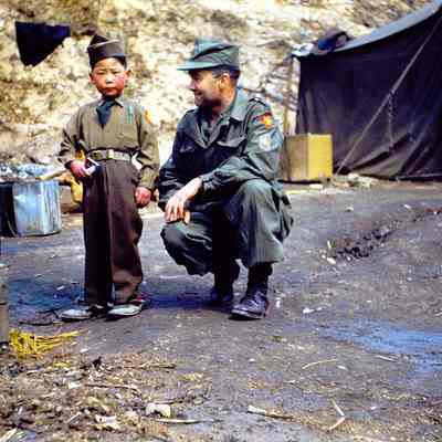 Soldier with a young boy dressed in a Thunderbird uniform
