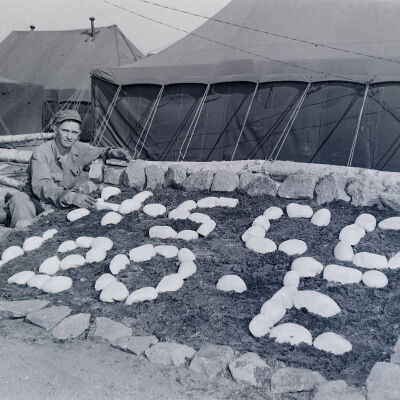 Soldier in front of camp rock garden sign