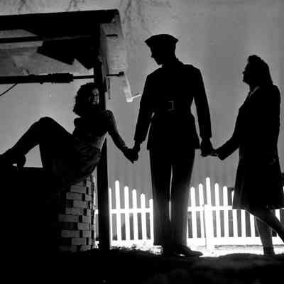 Soldier holding hands with two girls