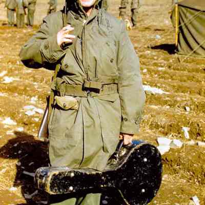 Soldier holding a cigarette and guitar case