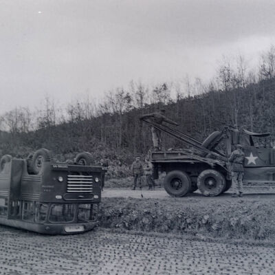 Army wrecker retrieving a wrecked bus